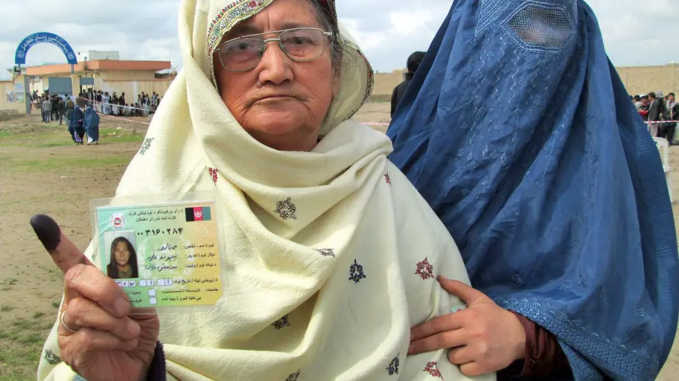 Una mujer muestra su tarjeta de registro de voto