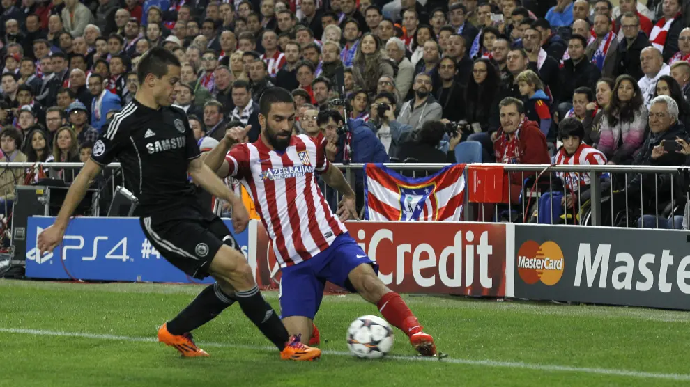 El centrocampista turco del Atlético de Madrid Arda Turan (d) pelea un balón con César Azpilicueta (i), del Chelsea.