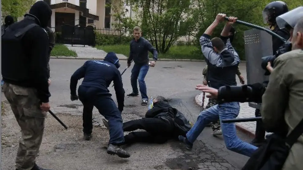Un grupo de jóvenes golpean a un manifestante tendido en el suelo
