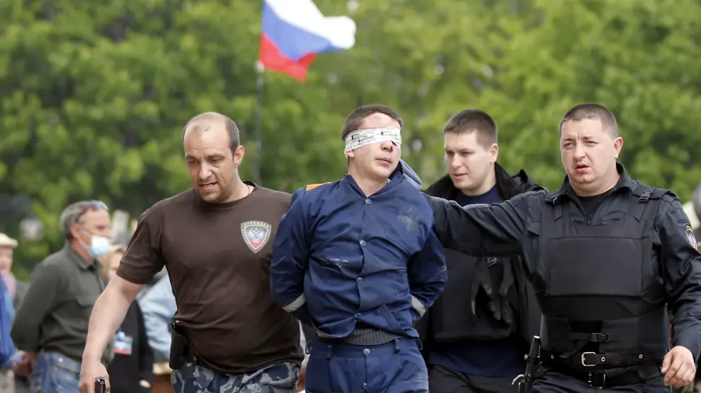 Activistas prorrusos escoltan a un hombre sin identificar en Donetsk