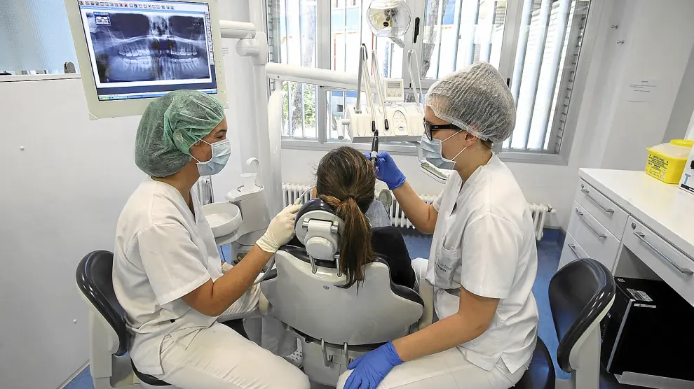 Cristina Artiles ?izquierda? e Inés Casado atienden a una paciente en la clínica universitaria de Huesca.
