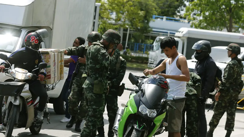 Soldados tailandeses requisan una moto en la zona cercana a los manifestantes