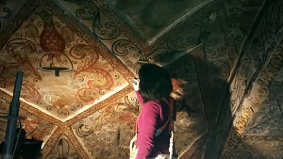 Una restauradora trabaja en una de las pinturas del siglo XVIII