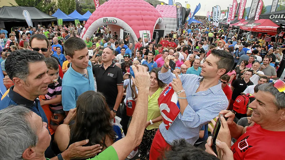 Miguel Indurain, a la izquierda, rodeado de aficionados ayer en la base de la Quebrantahuesos en Sabiñánigo.