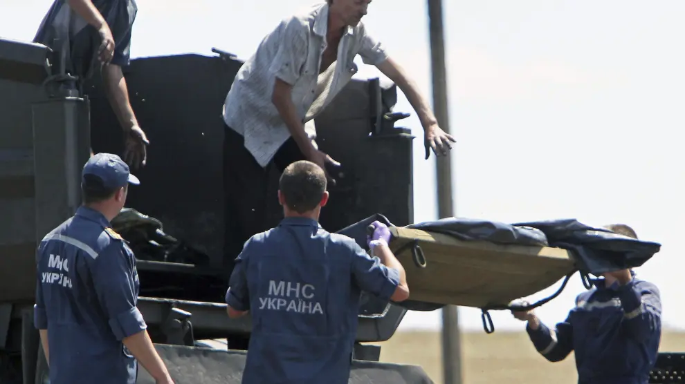 Trabajadores trasladan los cuerpos de los fallecidos en el accidente de avión