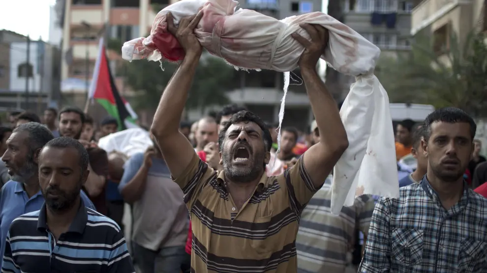 Un hombre sostiene el cuerpo de su hijo, fallecido por la ofensiva israelí