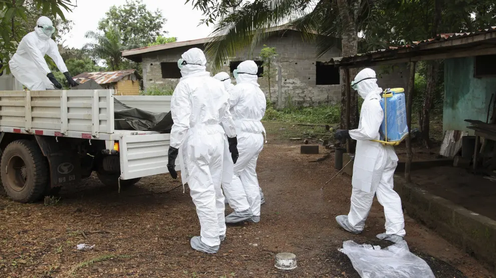 Varios trabajadores sanitarios liberianos desinfectan una casa en la que ha muerto una persona infectada de ébola tras retirar el cadáver.