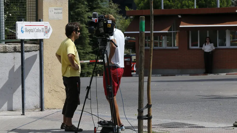 Dos reporteros de televisión graban en las inmediaciones del Hospital Carlos III