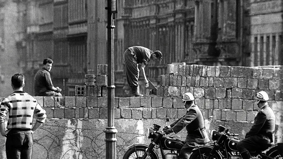 Soldados alemanes levantando el muro, ante el asombro de los ciudadanos.