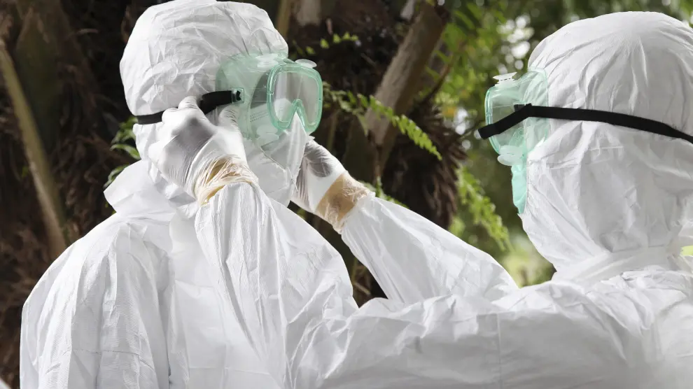 Dos enfermeros liberianos revisan sus equipos de protección contra el virus del ébola.