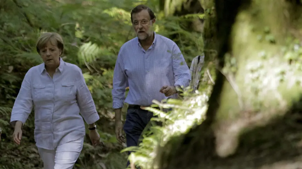 El presidente del Gobierno, Mariano Rajoy (d), y la canciller alemana, Angela Merkel (i), recorren a pie un tramo del Camino de Santiag
