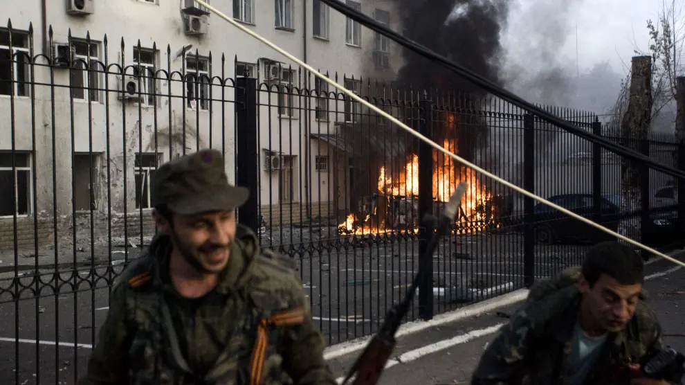 Los separatistas prorrusos se alejan de un coche en llamas