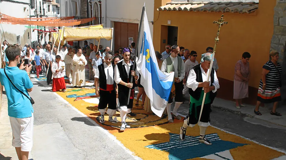 La procesión pasa por encima de las alfombras multicolores y las desdibuja.