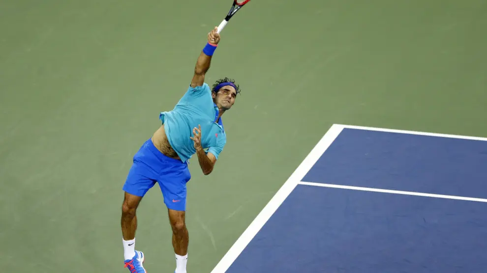 Roger Federer saca una bola durante el partido