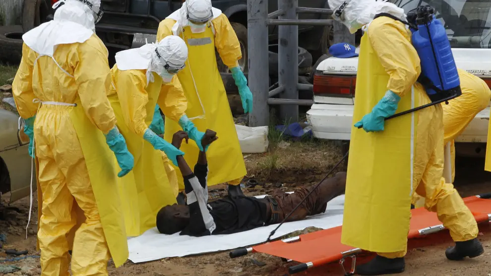 Varios especialistas transportan el cuerpo sin vida de una víctima del virus del ébola.