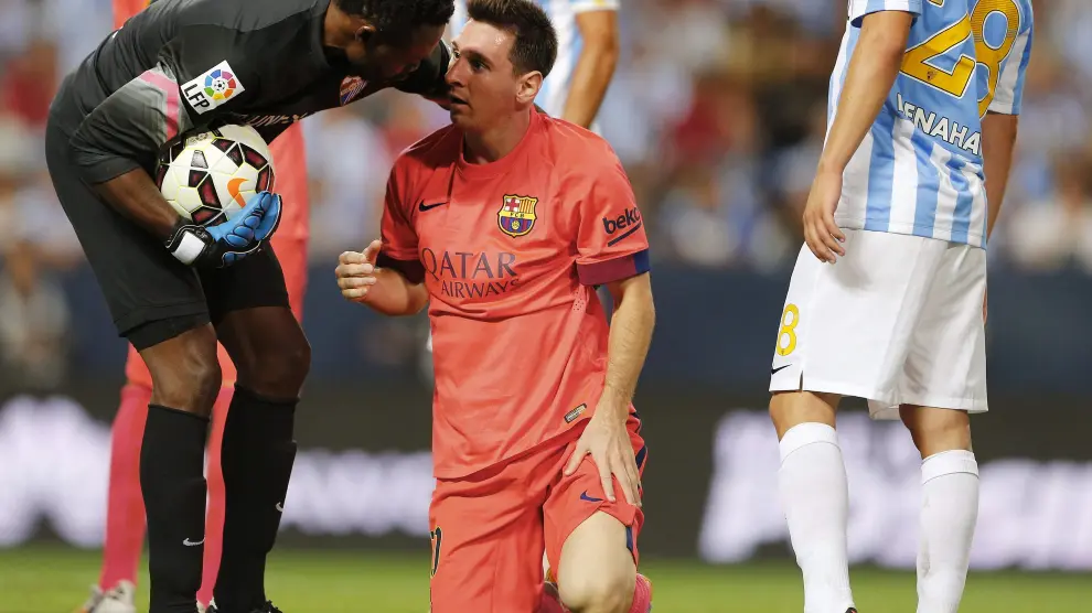 El árbitro habla con Messi en un momento del Málaga - Barcelona
