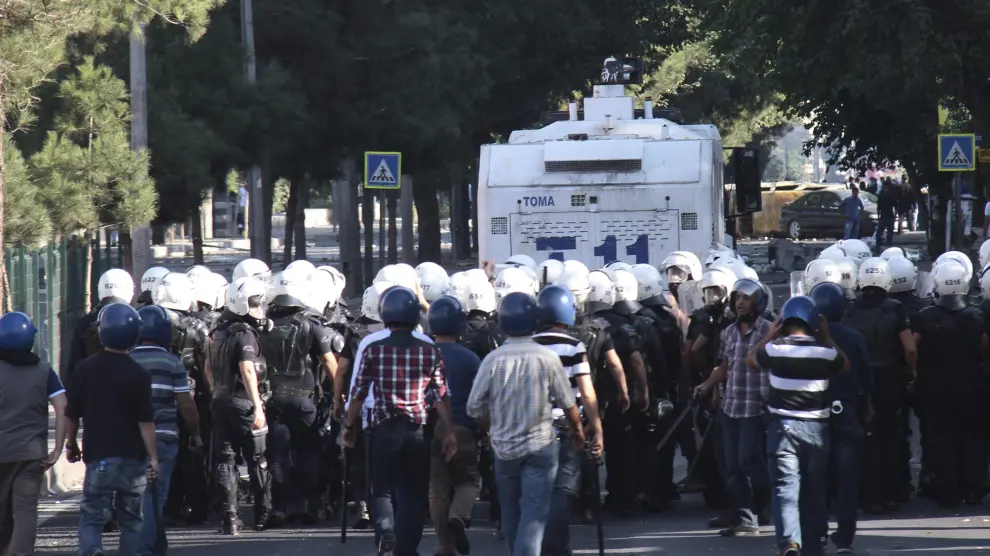 Policías antidisturbios se enfrentan a manifestantes durante una manifestación contra el Estado Islámico