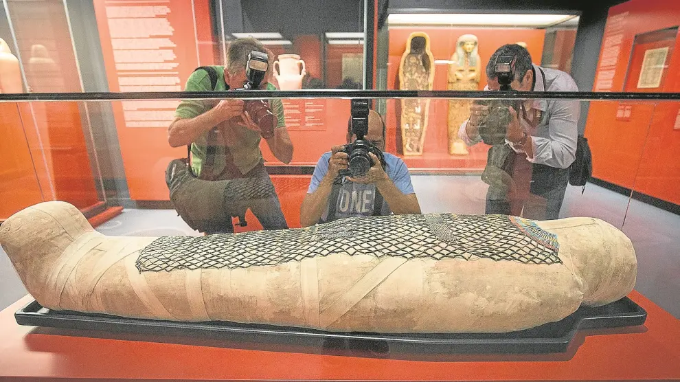Tres fotógrafos, ante la momia de Pauiamen, hallada en Tebas, y datada entre los años 712 y 525 antes de Cristo.