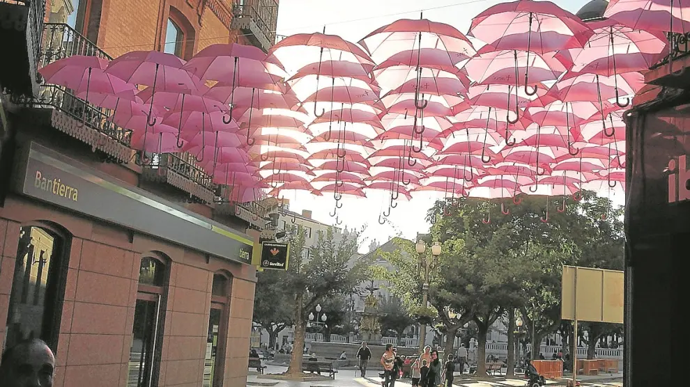 Paraguas rosas colgados en al calle de Berenguer, en Huesca, cerca de la sede de la AECC.