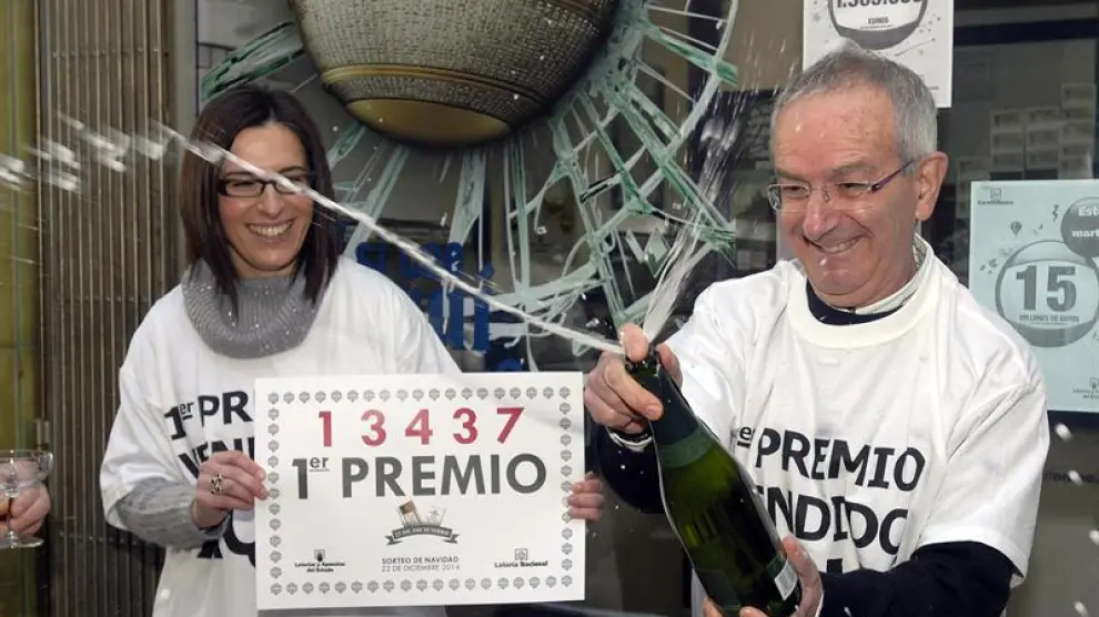 arlos Manso, dueño de la Administración de Lotería de Boñar (León) celebra el primer premio de la Lotería de Navidad, 13.437, del que ha vendido una serie.