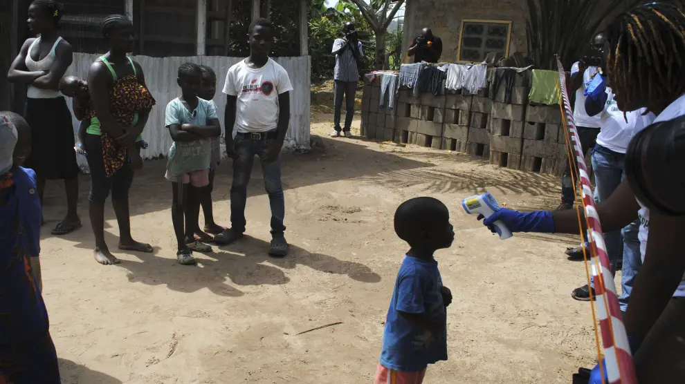 Un médico toma la temperatura a un niño en un barrio de Monrovia, en Liberia, el pasado miércoles