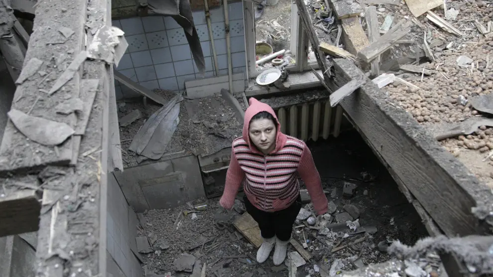 Una mujer observa los restos de su casa destruida en el centro de Donetsk, al este de Ucrania