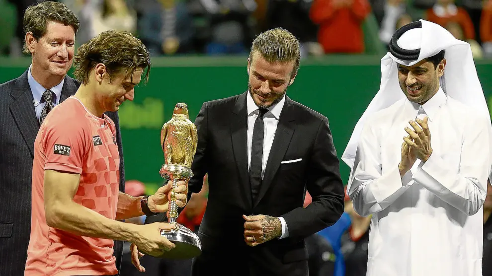 David Ferrer recibe de manos de David Beckham el trofeo de ganador del torneo de Doha.