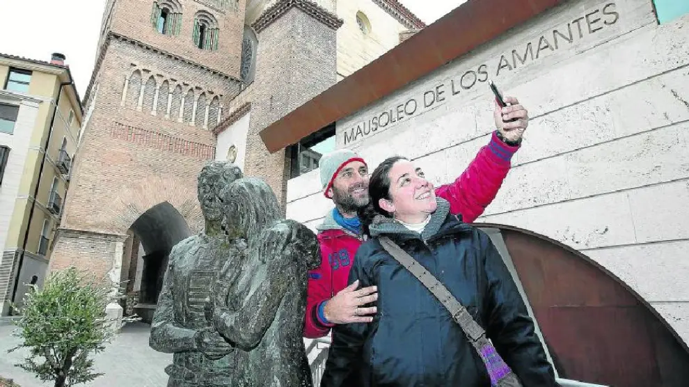 Nuria y Fernando, una pareja malagueña, aprovechó su visita turística a Teruel para hacerse una foto junto  a la recién inaugurada escultura de los amantes que se encuentra  lindando al mausoleo.