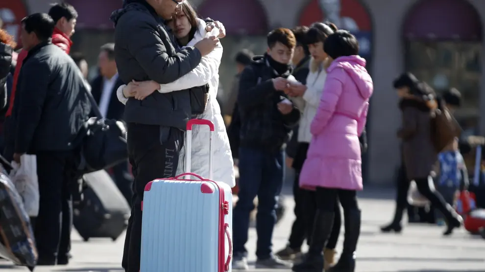 Una pareja se abraza en Pekín antes de separarse para visitar a sus familias por Año Nuevo