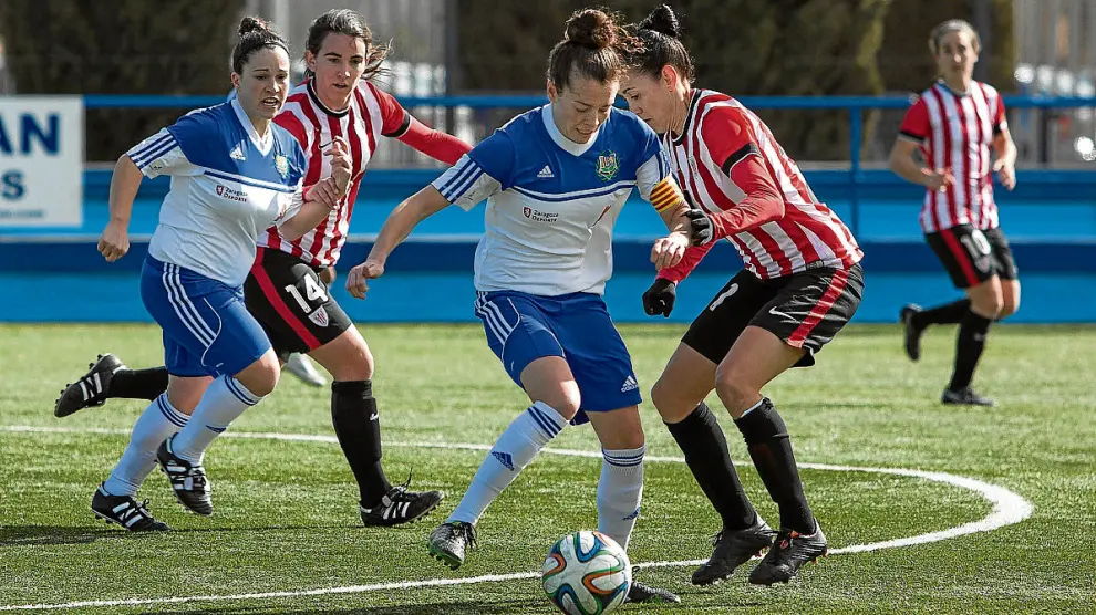 Nuria Mallada intenta controlar el balón ante la presión de una jugadora del Athletic.