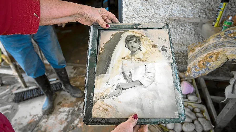 Mª Pilar Oquendo muestra el estado en el que ha quedado su foto de boda tras inundarse su casa.