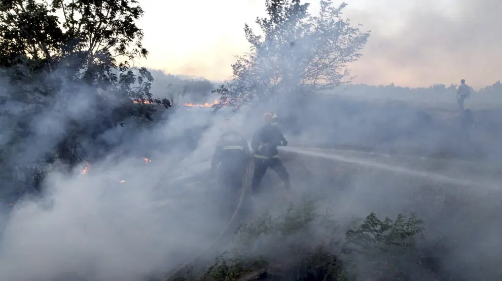 Labores de extinción del incendio forestal declarado en la tarde de este viernes en el término oscense de Alcolea