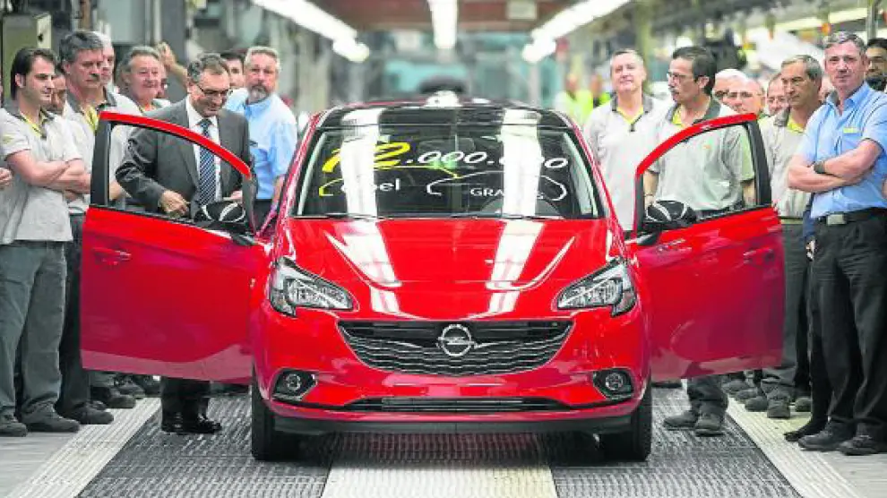 Antonio Cobo, director de GM España, y Francisco Gil, operario, sacando de línea el coche 12 millones.