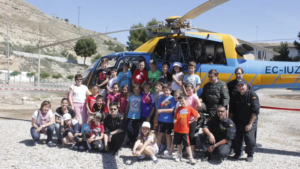 Un grupo de escolares posa junto al helicóptero de la DGT.