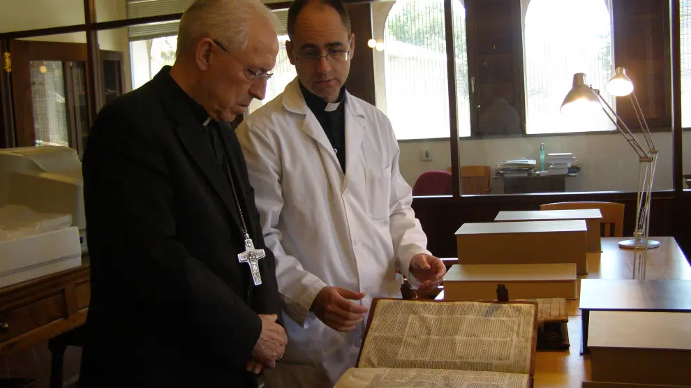 El obispo de la diócesis de Tarazona revisa los preciados manuscritos junto con el canónigo archivero.