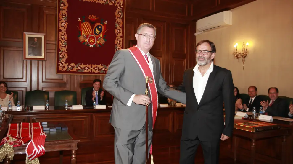 El popular Manuel Blasco, a la izquierda, recibe el bastón de mando de manos del presidente de la mesa de edad, Paco Martín, de CHA.