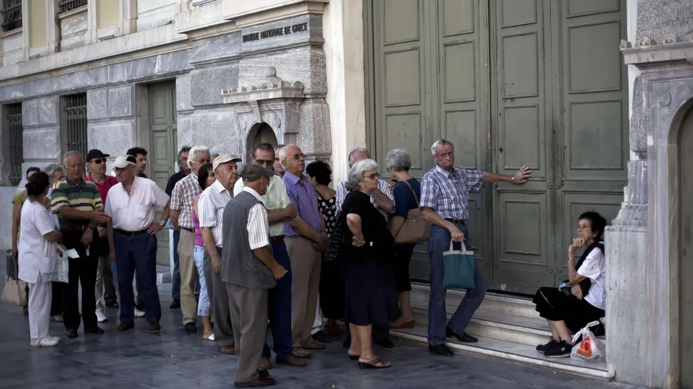 Un grupo de jubilados espera en la puerta del Banco Nacional de Gracia. (Archivo)