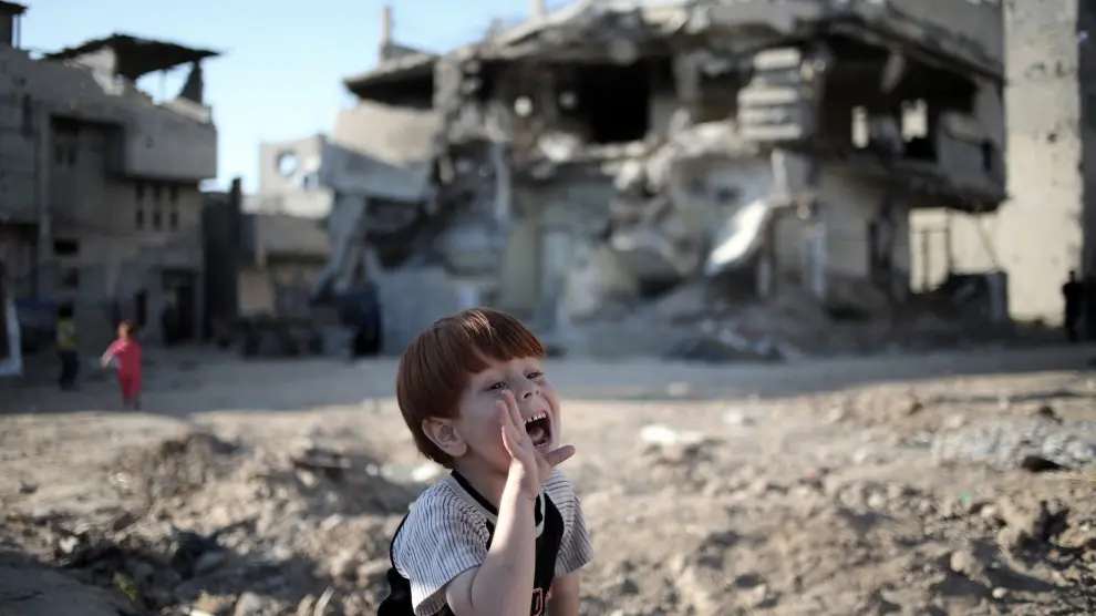 Ahmad Al Moghani, de cinco años de edad, juega con sus amigos en un paisaje desolador.