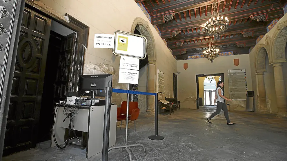 En el vestíbulo del Ayuntamiento de Huesca solo queda ahora la mesa donde está la pantalla para ver las imágenes de las cámaras.