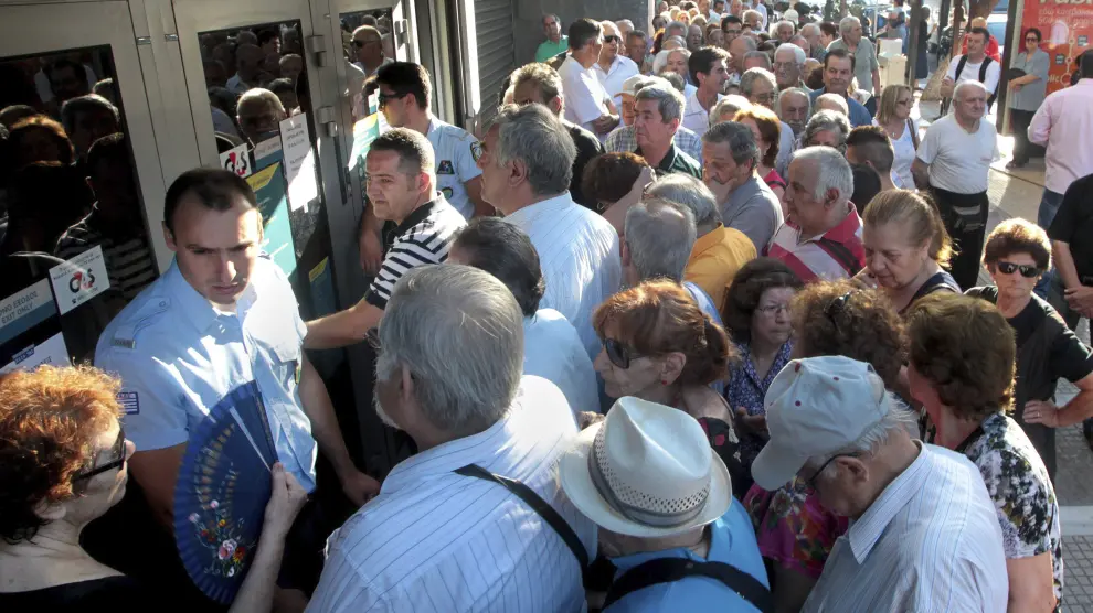 Pensionistas que no poseen tarjeta de crédito hacen cola para cobrar en una sucursal del Banco Nacional de Grecia.