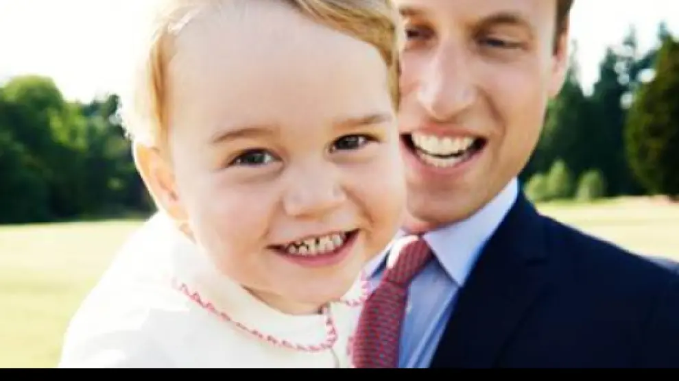 El príncipe Jorge en brazos de su padre.