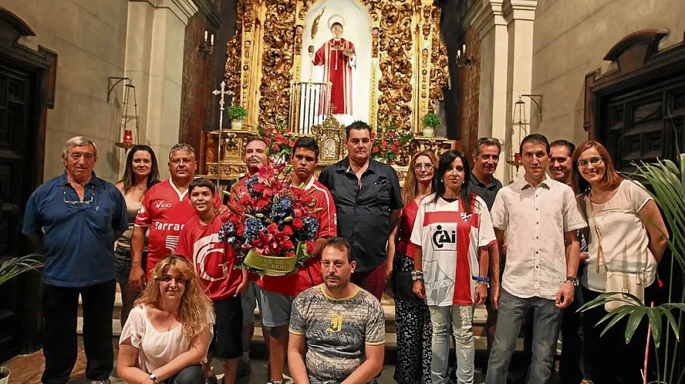 Los socios de la peña Fenómenos Oscenses dejaron el centro de flores en la capilla de San Lorenzo.