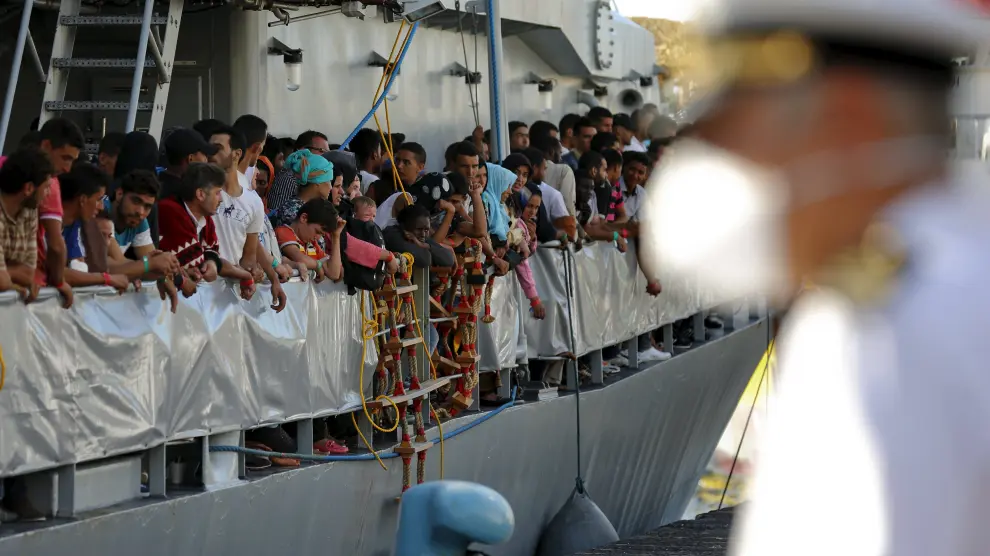 Inmigrantes desembarcando en el puerto italiano de Messina.