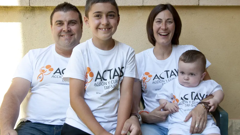 El pequeño Hugo (d), de 16 meses, junto a sus padres y su hermano vestidos con las camisetas de la asociación Actays.