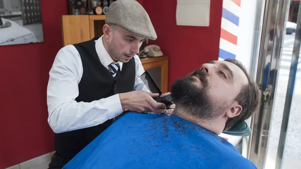 Un hombre se recorta la barba en una barbería de Zaragoza
