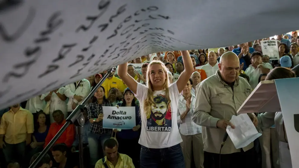 La esposa de Leopoldo López sostiene un cartel con los nombres de los presos políticos venezolanos.