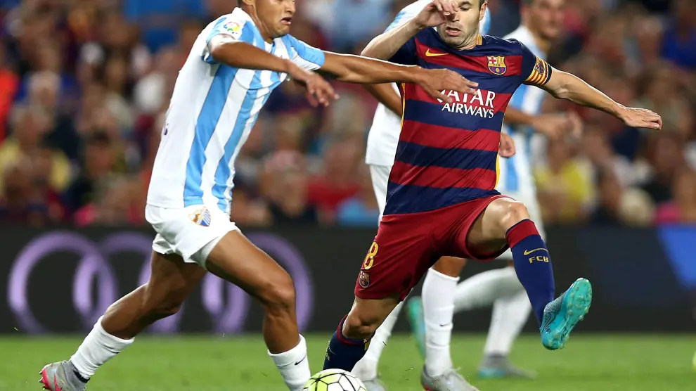Iniesta lucha el balón con Juanpi, durante el partido de la segunda jornada del Campeonato de Liga.