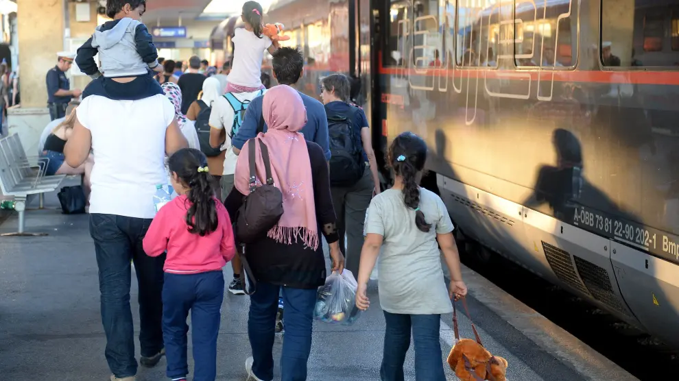 Varios refugiados procedentes de Hungría se suben a un tren con destino a Alemania.