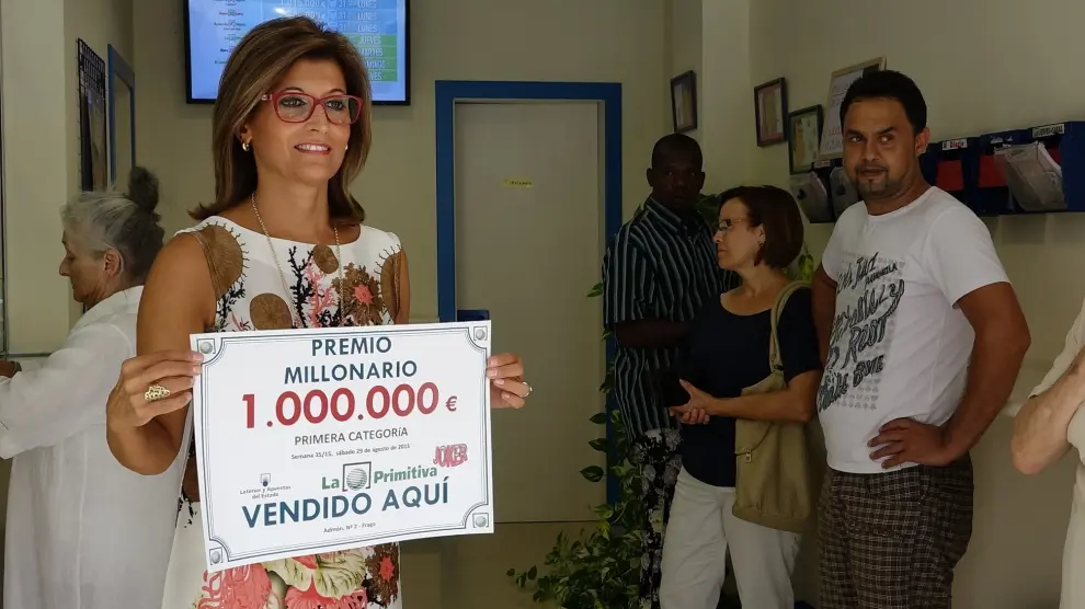 La propietaria de la administración, Andrea Ballesté, muestra el cartel del millonario premio.