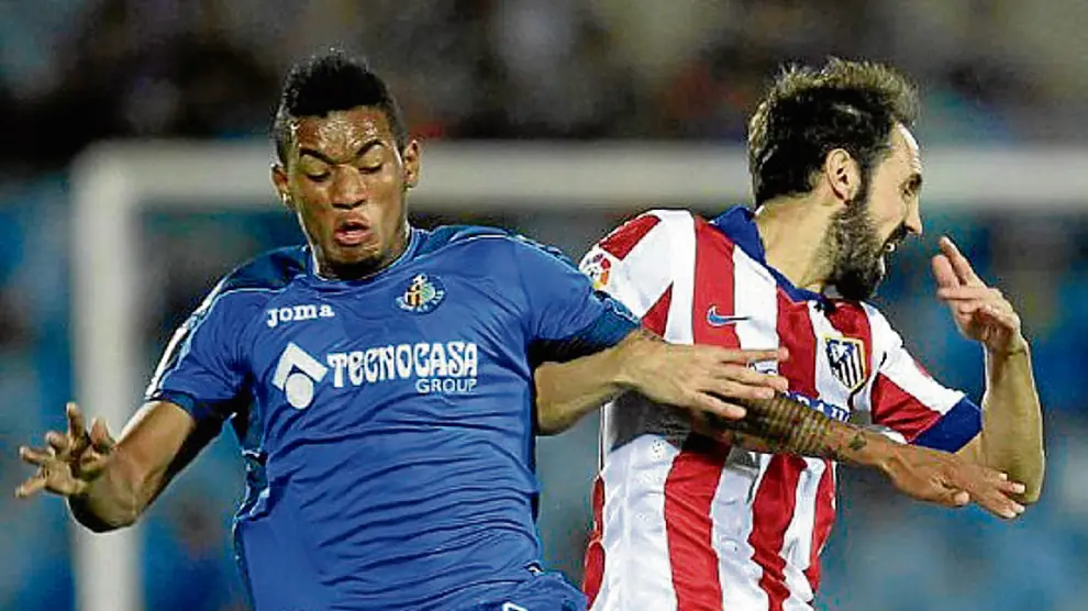 Freddy Hinestroza, con la camiseta azul del Getafe, pugna con Juanfran, lateral del Atlético de Madrid.